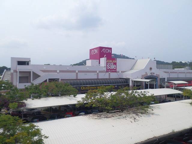 The white AEON shopping centre in Ayer Keroh with a pink AEON tower and covered car park in front