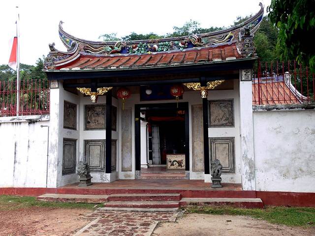 The small Poh San Teng temple at the foot of Bukit China with a curved, decorated Chinese roof and white walls