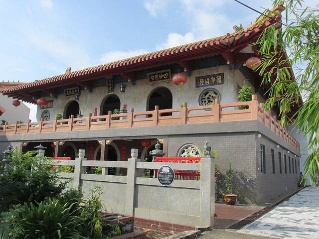 The two-storey Xiang Lin Si Buddhist temple in Melaka with a tiled roof, red lanterns and a stone balustrade