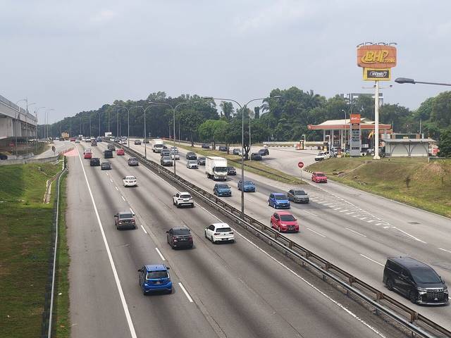 Car repair in Selangor: traffic on the Federal Highway near Shah Alam, with a petrol station beside the road