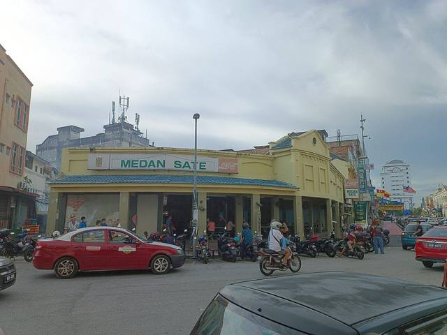 Medan Sate, a corner shophouse restaurant with a green sign in Kajang town centre, the home of satay Kajang, with motorbikes parked outside